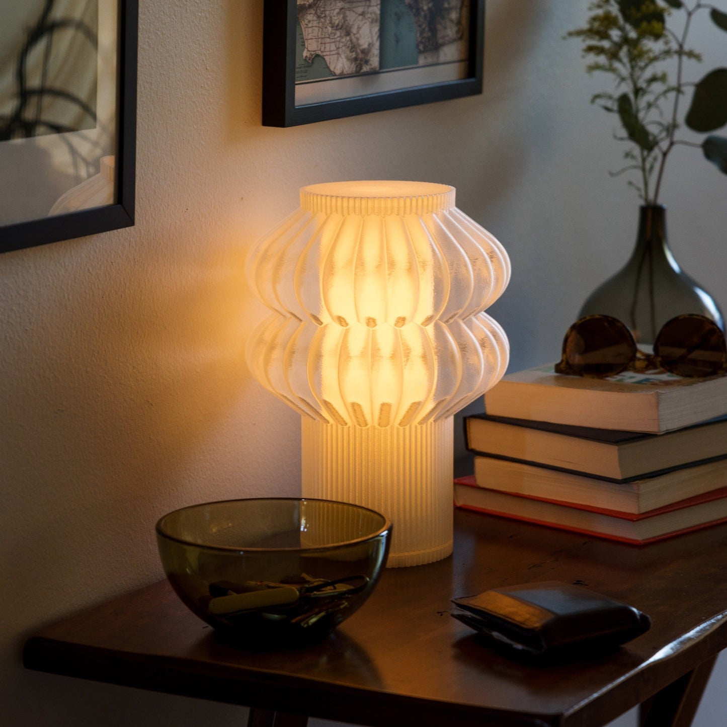 Terra Labs Oppi table lamp with a modern design featuring a sleek base and a soft fabric lampshade on a wooden table.