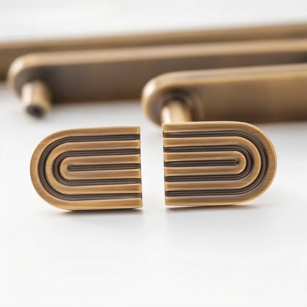 Brass Blaris knob and pull bar set, art deco style cabinet hardware from Residence Supply, mounted on a wooden cabinet.