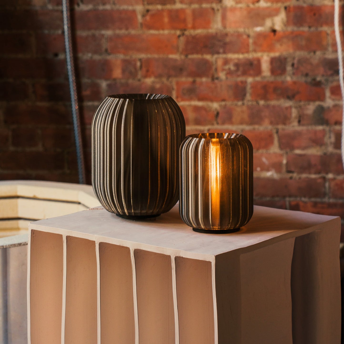 Wooj Design Mini Allium Lamp with smoke-colored glass and sleek modern design, illuminated and showcasing its elegant shape.