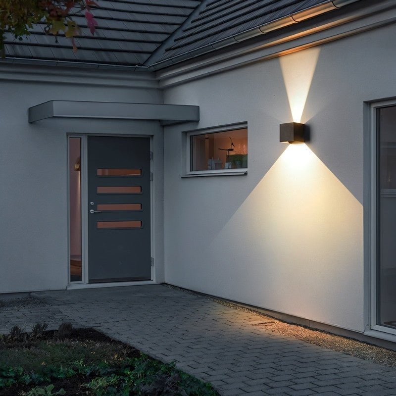 Residence Supply Tine Wall Lamp mounted on entryway wall, featuring modern design with a sleek metal finish and warm lighting.