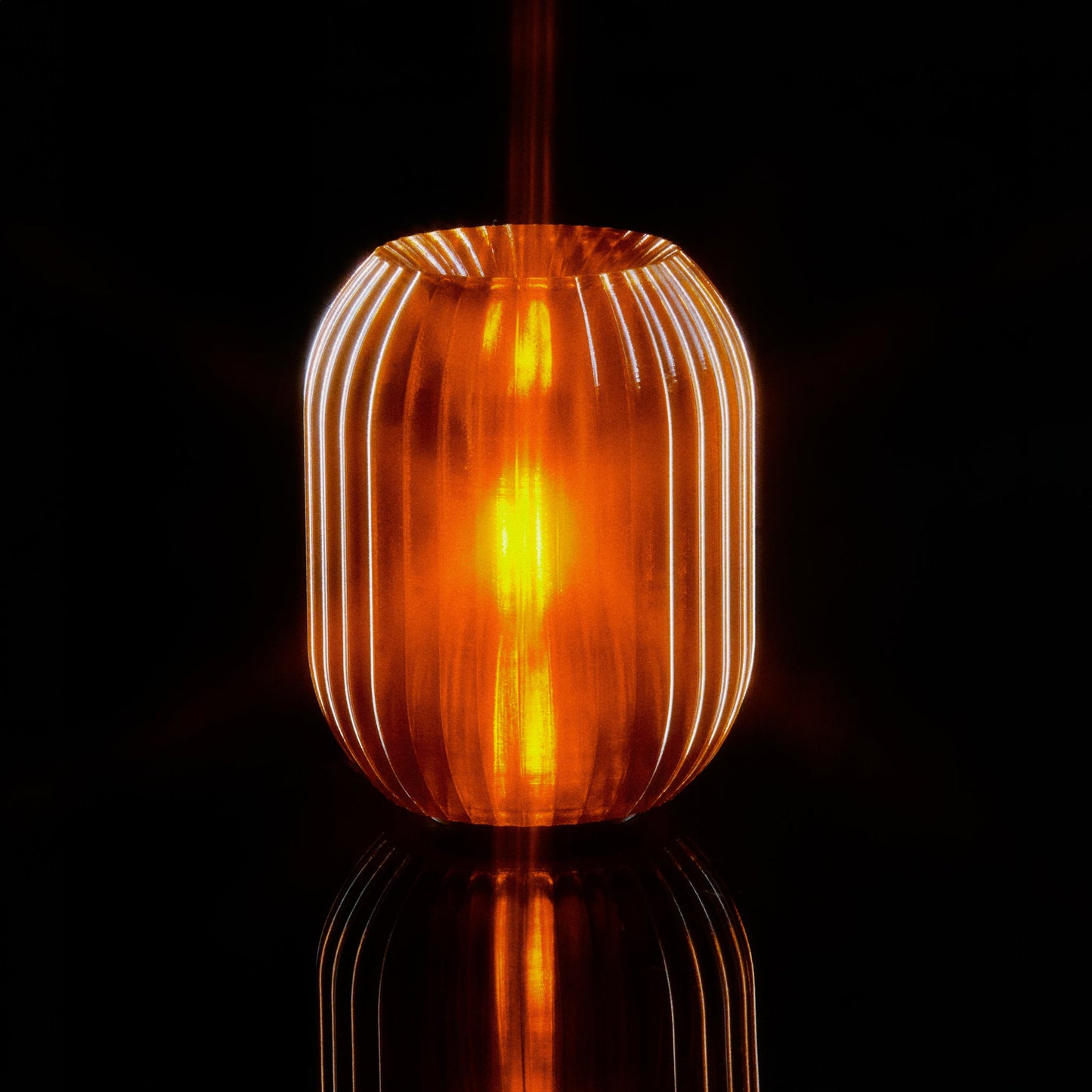 Allium Lamp by Wooj Design featuring a warm amber glass shade and modern floral-inspired design on a sleek base.