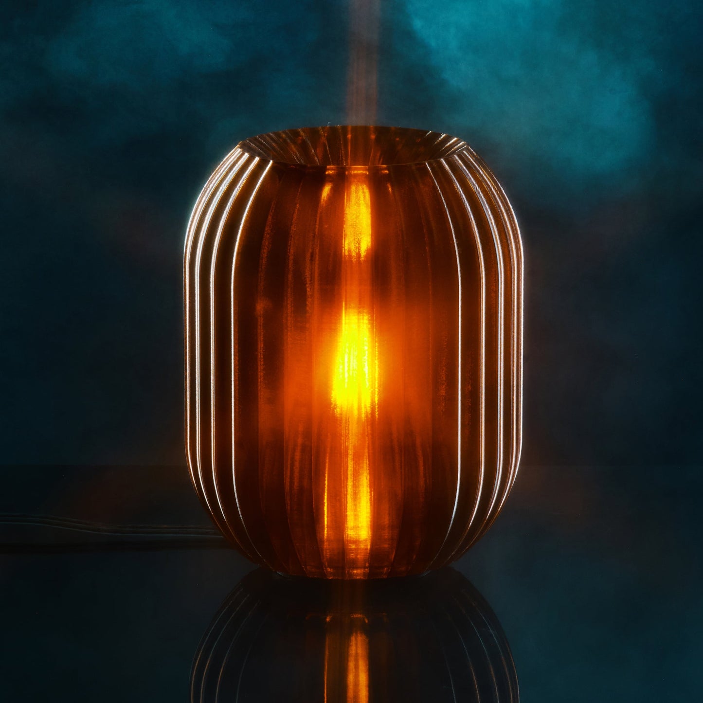Allium Lamp by Wooj Design featuring a glowing amber-colored ceramic bulb-shaped lamp on a wooden surface.