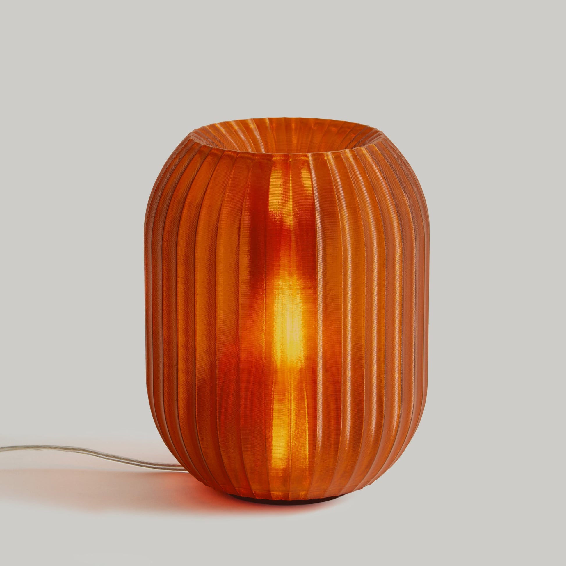 Allium Lamp by Wooj Design featuring a modern amber glass design with a bulbous, layered shape suitable for contemporary decor.