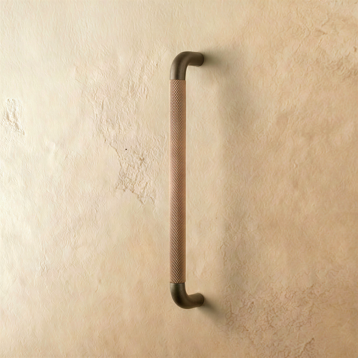 A brown Alyma knob and pull bar for cabinets, made of metal, with a sleek curved design, suitable for kitchen or furniture hardware.