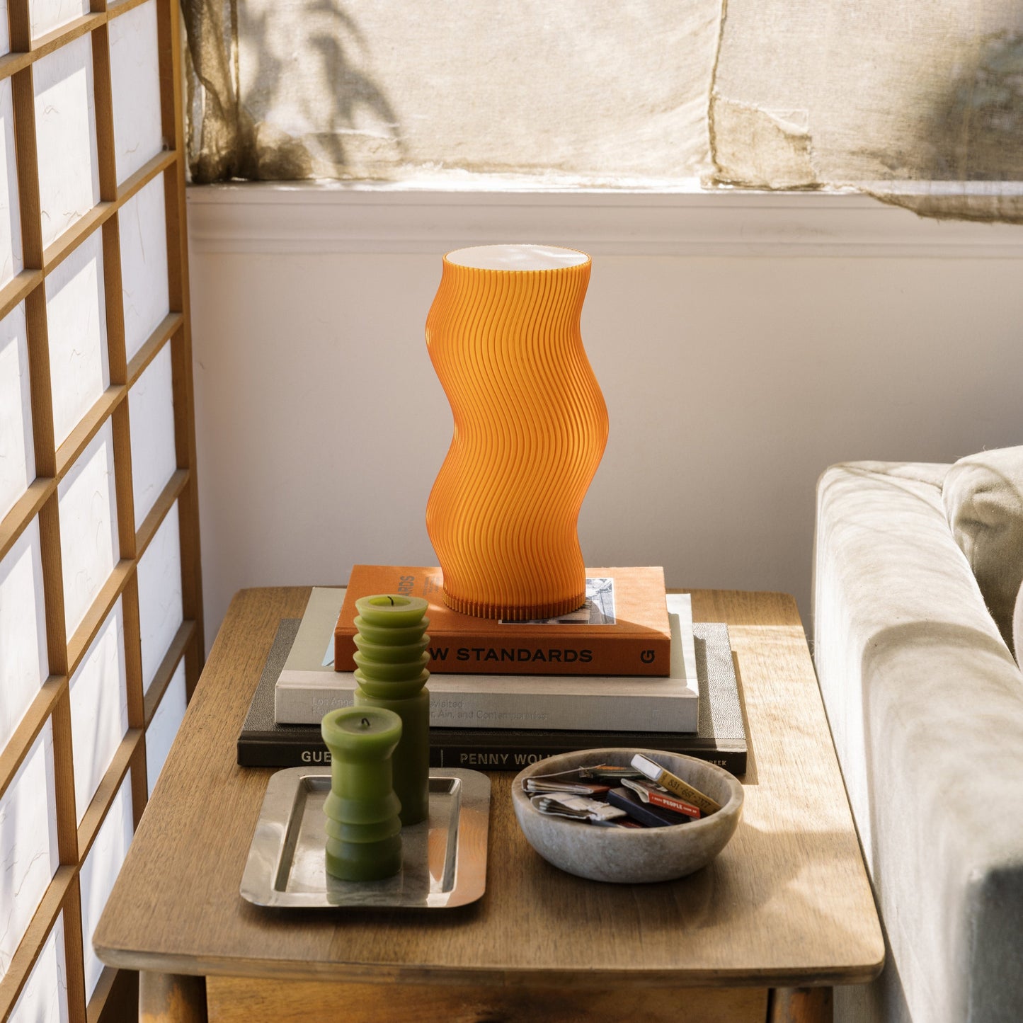 Terra Labs Woogie Table Lamp with a modern, sculptural design and warm lighting, placed on a wooden table for ambient decor.