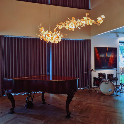 Korewolamp Gingko Ceramic Chandelier with leaf-shaped design, hanging from a ceiling with warm lighting and decorative chain.