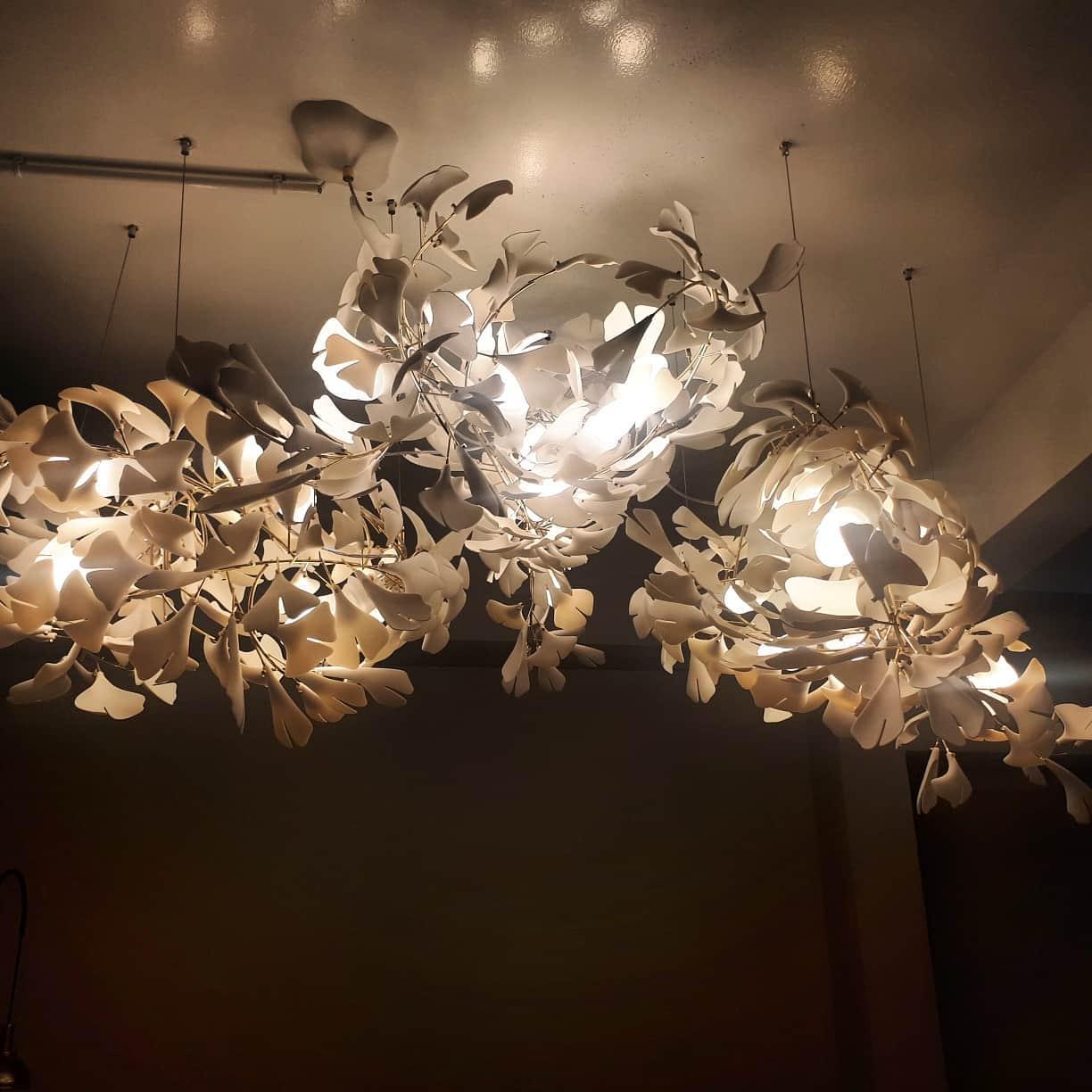 Ginkgo ceramic chandelier by Korewolamp featuring leaf-shaped design with white ceramic leaves and warm lighting.