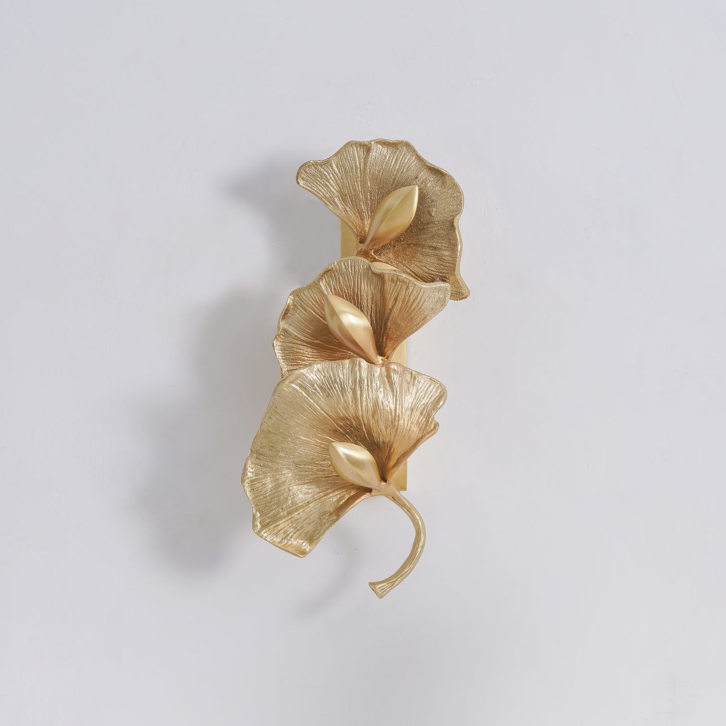 Korewolamp ginkgo leaf wall lamp with a delicate leaf design mounted on a wall, emitting warm ambient light.