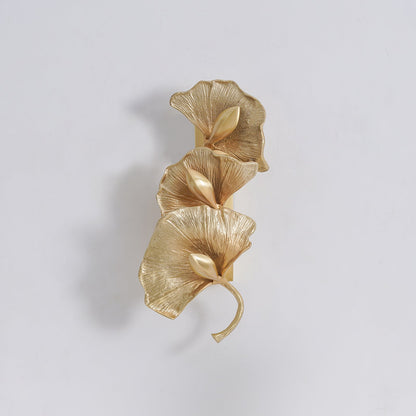 Korewolamp ginkgo leaf wall lamp with a delicate leaf design mounted on a wall, emitting warm ambient light.