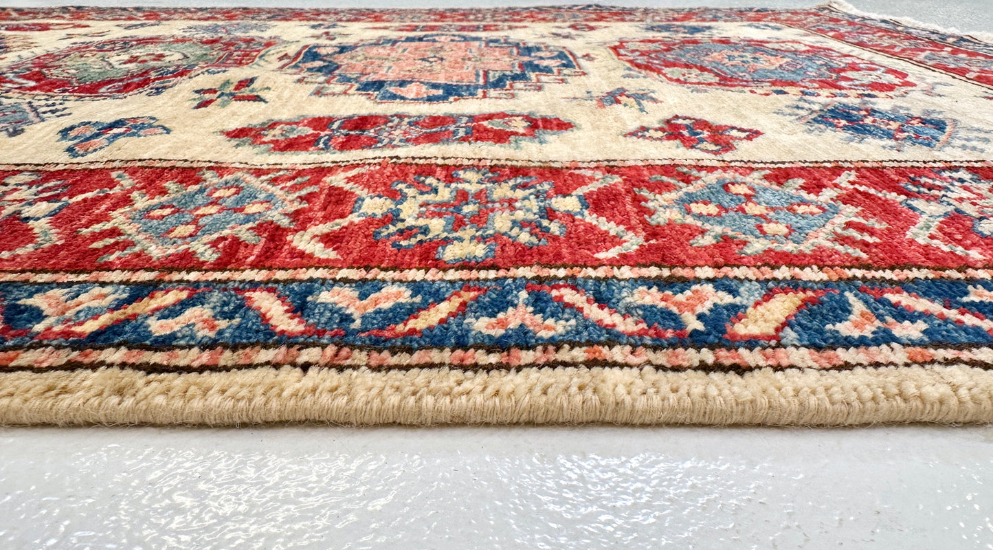 Kirishian Rugs Super Kazak 3'01" x 5'00" ivory and red woven wool rug with intricate geometric patterns.