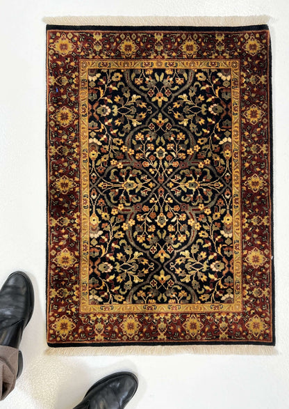 Kirishian Rugs IndoFarahan black and rust 2x3 fiber rug with geometric pattern on neutral background.