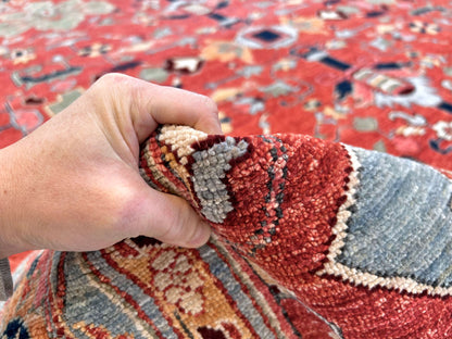 Afghan Heriz rug by OneKind, 9'07" x 13'09", in light red and light blue, showcasing intricate traditional geometric patterns.