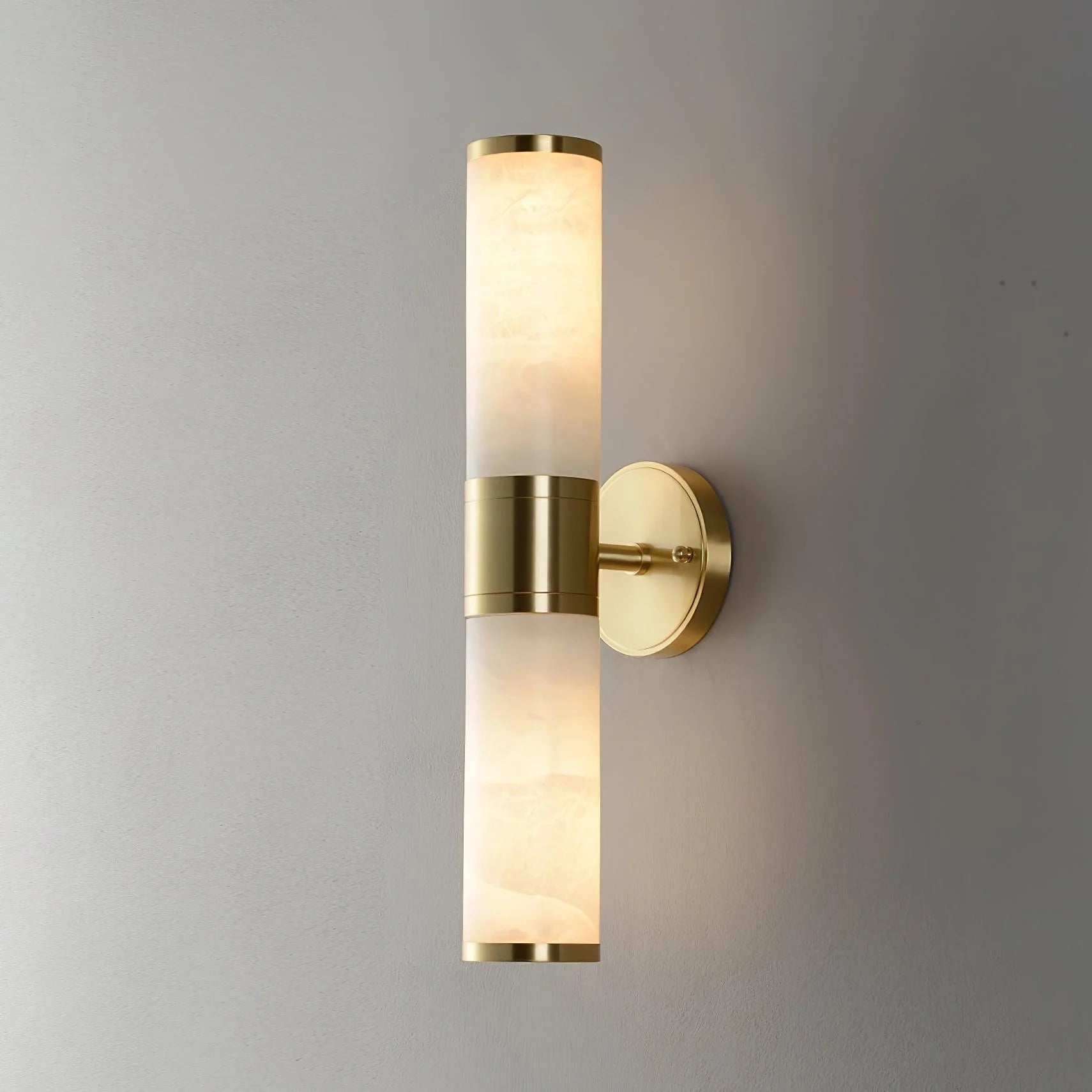 Alabaster Lampatron cylindrical wall lamp by Korewolamp with a sleek marble finish, mounted on a wall for ambient lighting.