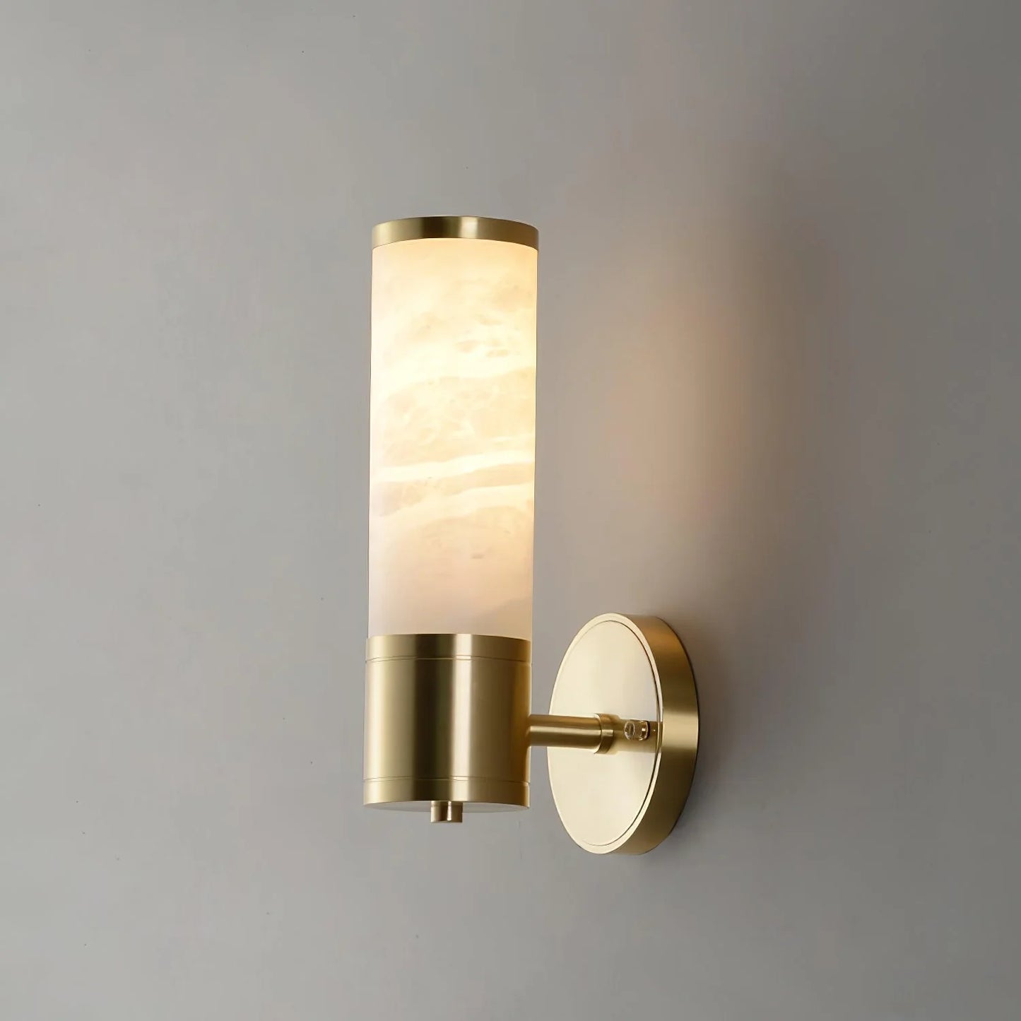 Alabaster Lampatron cylindrical wall lamp by korewolamp hanging on a wall, showcasing its smooth alabaster finish and modern design.