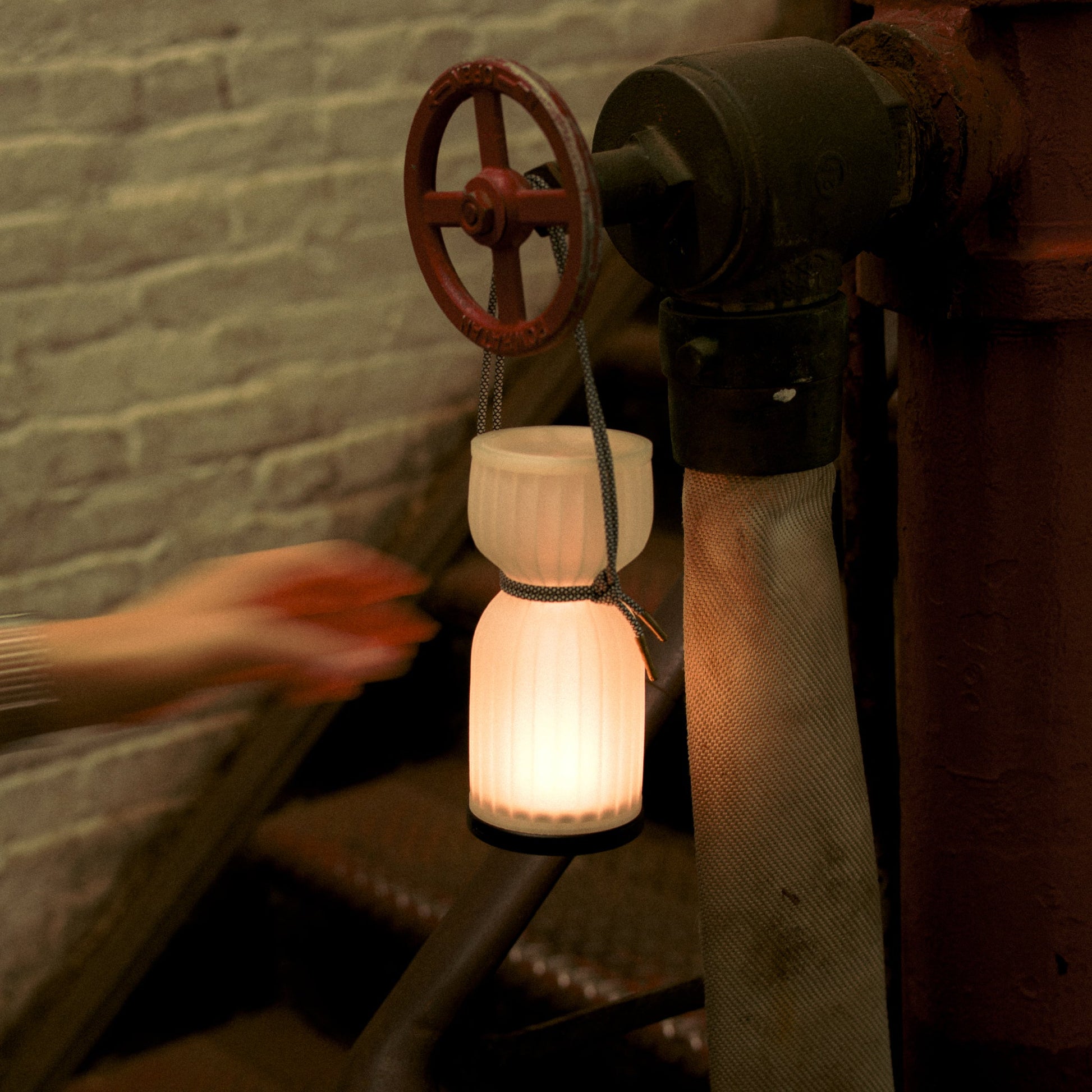 Wooj Design cordless camp lantern illuminating a campsite with a warm glow, ideal for outdoor camping and portable lighting.