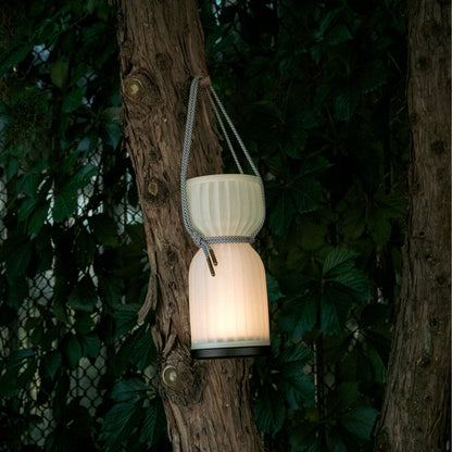 Wooj Design cordless camp lantern illuminating a camping tent in an outdoor setting during dusk.
