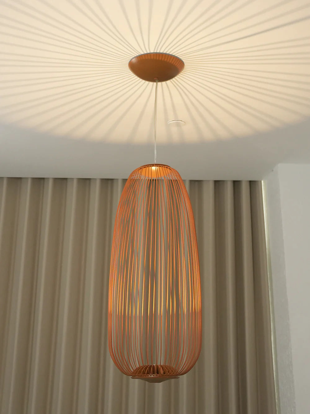 Lightweight spokes-shaped pendant lamp by korewolamp with a delicate cage design hanging from a ceiling mount.
