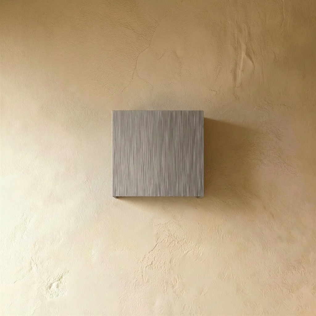 Brushed silver Lior Wall Lamp by Residence Supply mounted on a wall with a modern, minimalist design and adjustable arm.