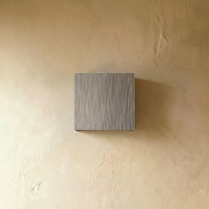Brushed silver Lior Wall Lamp by Residence Supply mounted on a wall with a modern, minimalist design and adjustable arm.