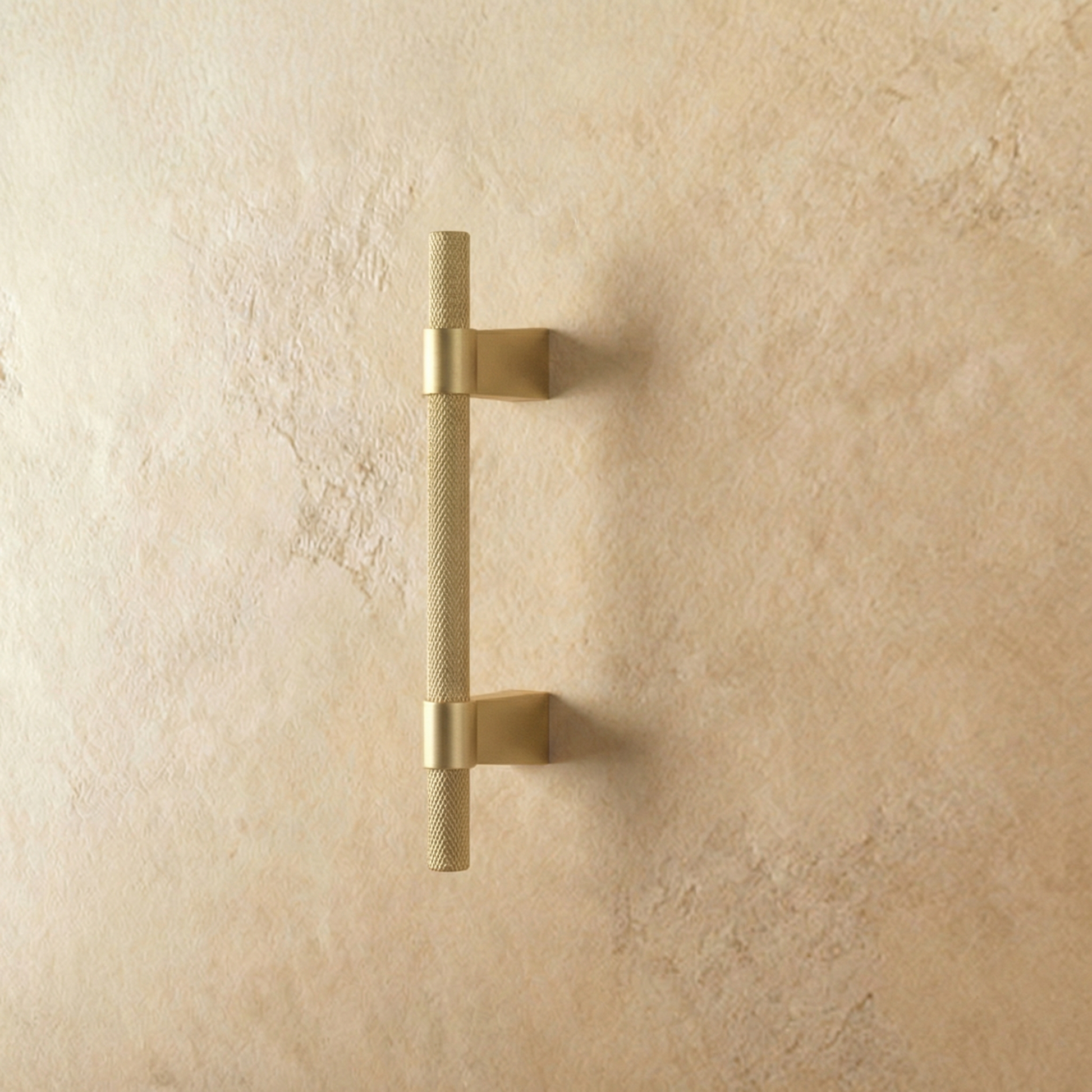 Golden Varai knob and pull bar from Residence Supply, cabinet hardware with sleek design, on plain background.