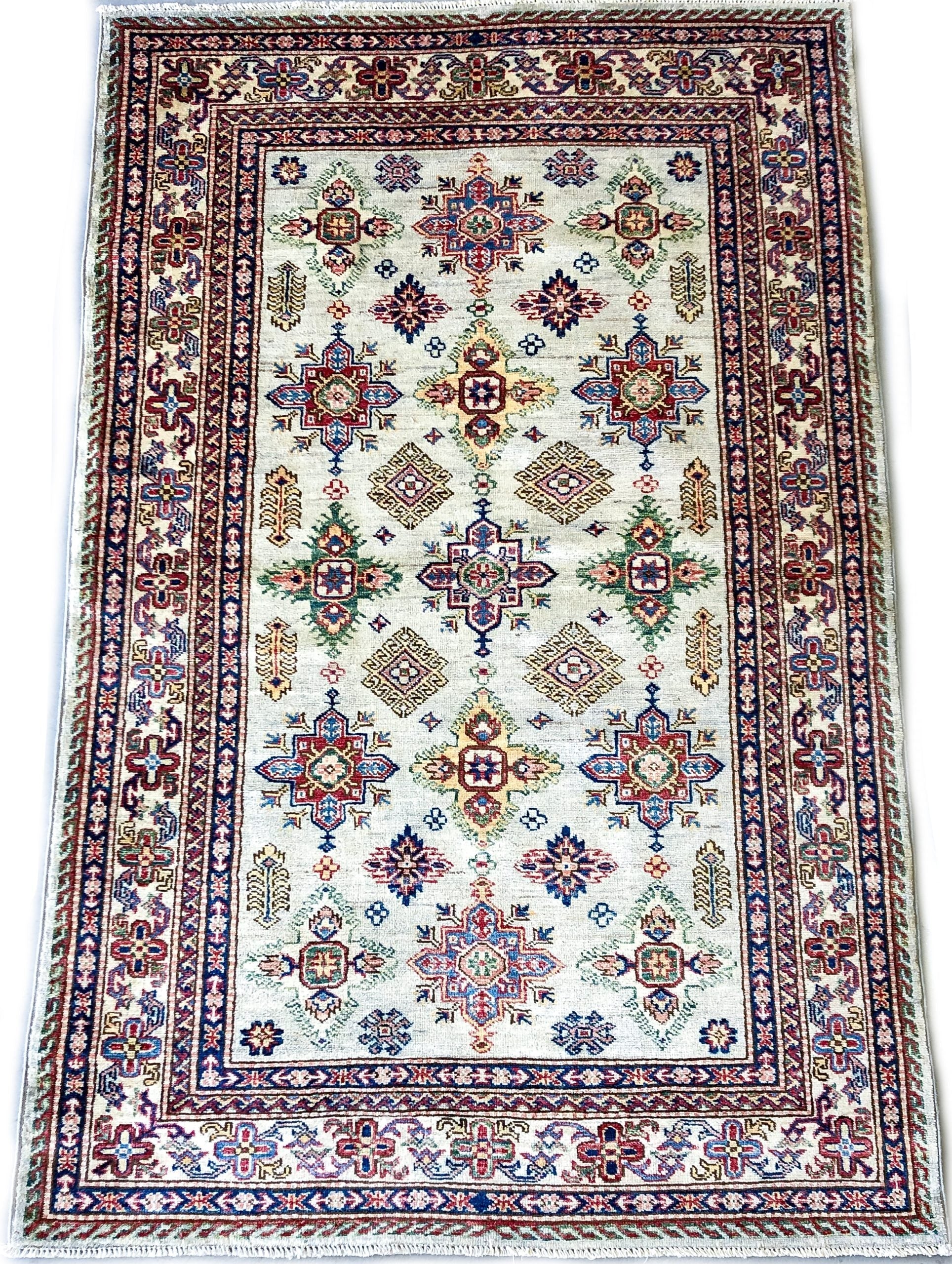 Kirishian Rugs Super Kazak ivory 4x6 closeout rug with intricate geometric patterns on a beige background, close-up view.