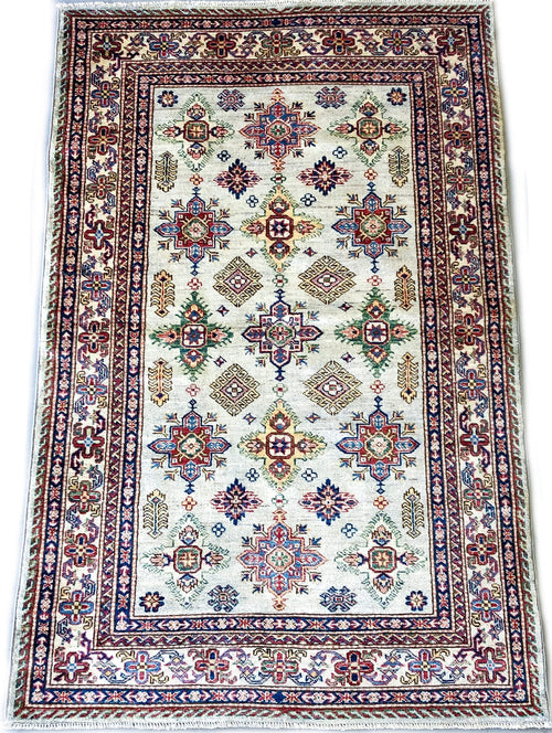 Kirishian Rugs Super Kazak ivory 4x6 closeout rug with intricate geometric patterns on a beige background, close-up view.
