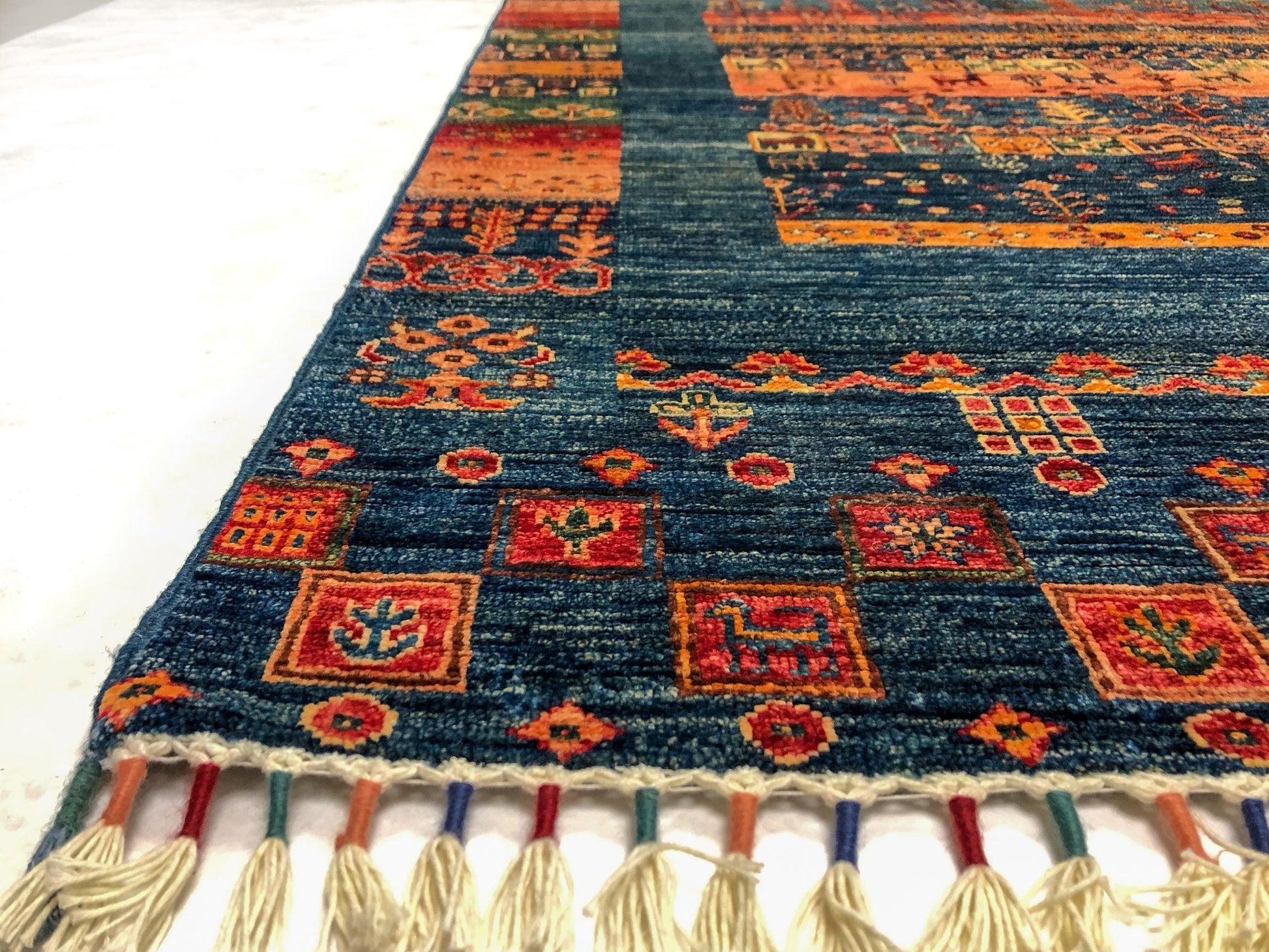 Closeup of a blue Gabbeh Khorjin rug by Kirishian Rugs showing intricate traditional patterns and rich woven textures.