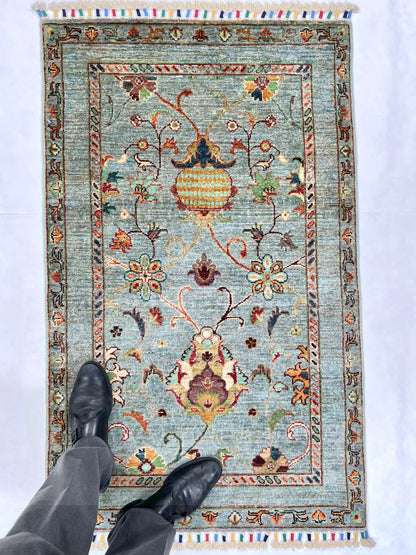 Afghan Khorjin rug by OneKind from Kirishian Rugs, light blue and multicolor, measuring 2'07" x 4'04" with intricate traditional patterns.