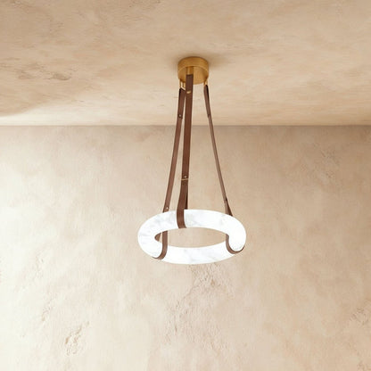 Aktis Alabaster Pendant Light by Residence Supply hanging from ceiling with warm glow and sleek modern design.