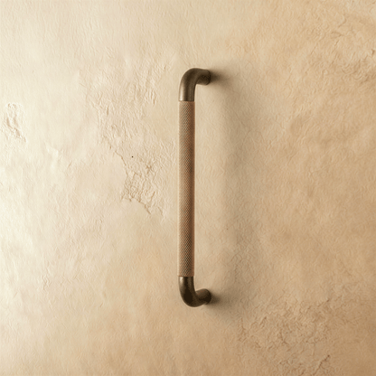A close-up of the Alyma knob and pull bar, bronze finish, designed for cabinet hardware in a home and garden setting.