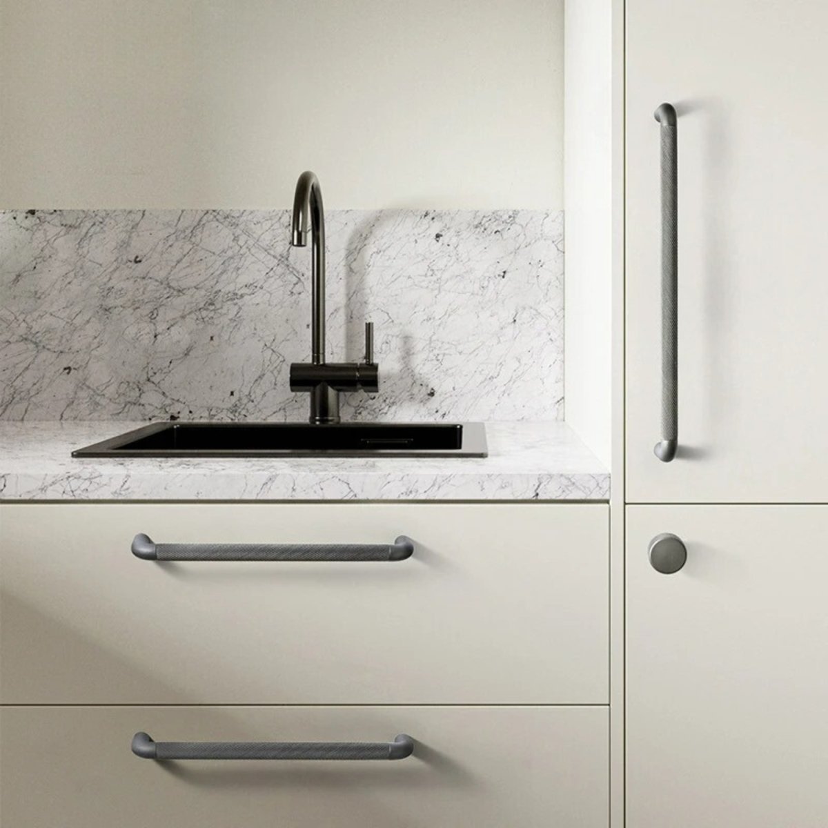 Alyma knob and pull bar in a sleek metal finish, designed for cabinet hardware in home and garden furniture.