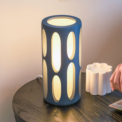 Terra Labs Amoeba Table Lamp with organic-shaped, translucent glass shade and modern design on a wooden surface.
