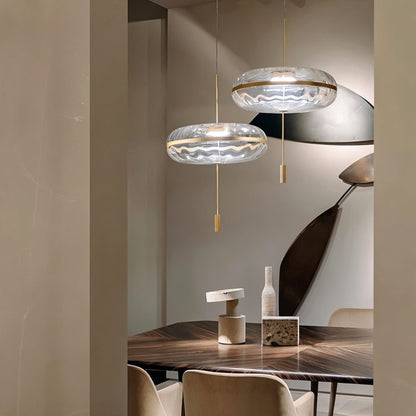 Sculptural glass Anala Pendant Light by Residence Supply hanging above a dining table with a modern design.
