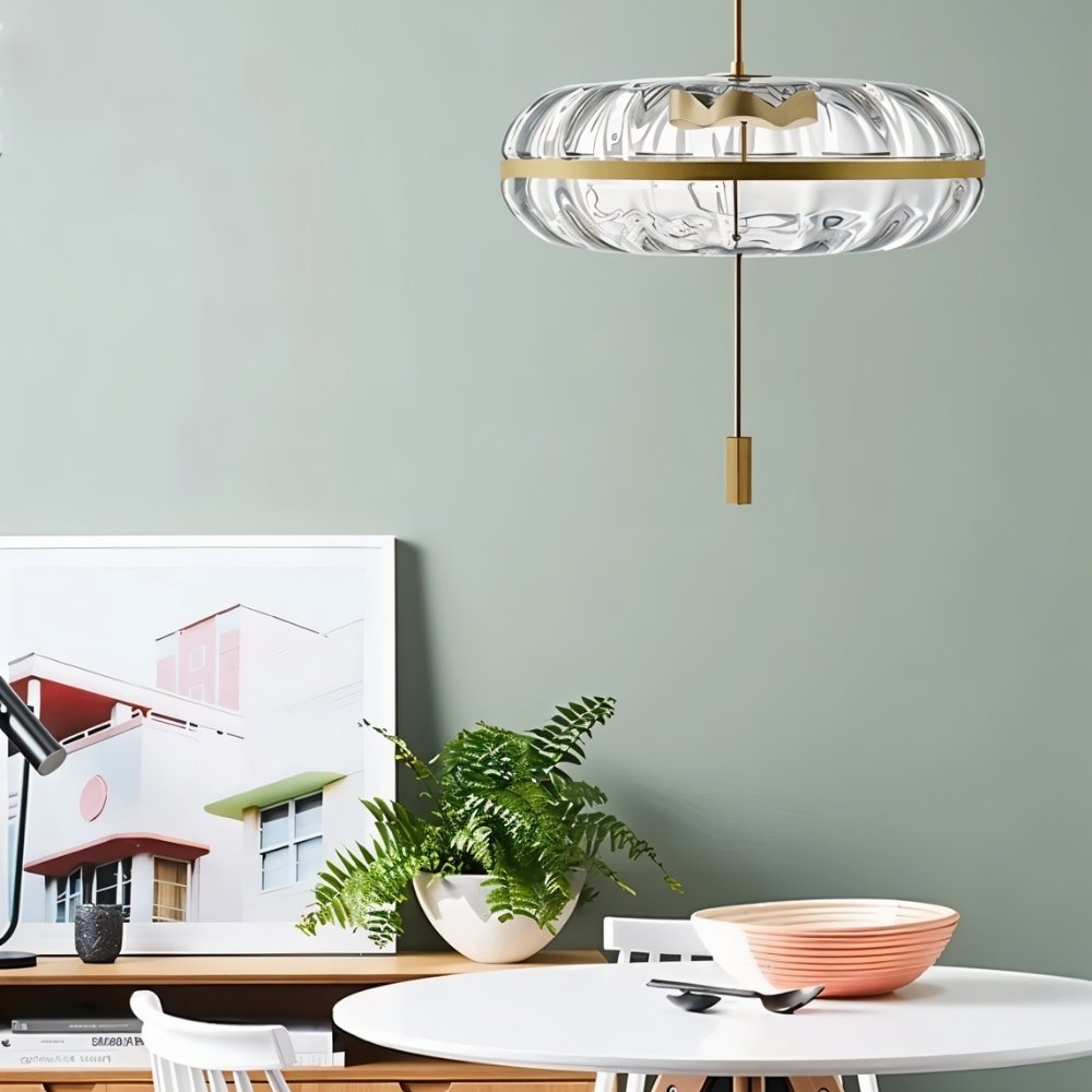 Residence Supply Anala pendant light with sculptural glass design hanging above a dining table.