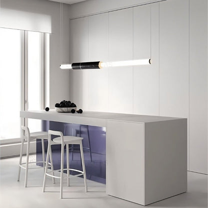 Modern Delia Pendant Light by Residence Supply hanging above a kitchen island, featuring sleek design and ambient lighting.