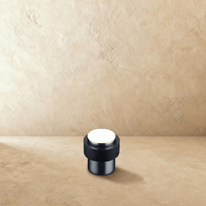 Residence Supply Desist Door Stop in metal with rubber tip, mounted on a door to prevent movement and protect walls.