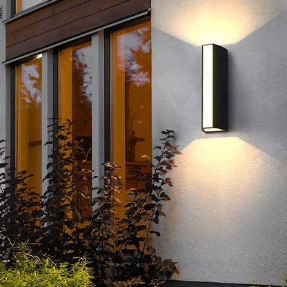 Residence Supply Erhan outdoor wall lamp mounted on exterior wall, featuring modern black metal design with glass shade.