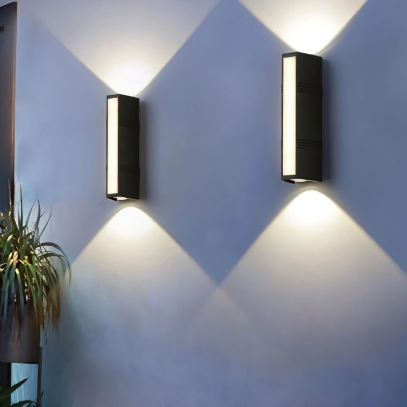 Outdoor wall lamp by Residence Supply with a sleek, modern design in black finish, mounted on a brick wall.