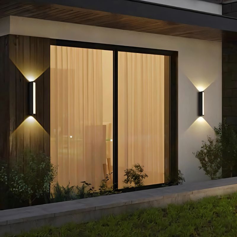 Erhan outdoor wall lamp by Residence Supply mounted on exterior wall with black metal finish and clear glass shade.