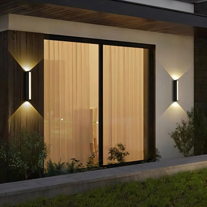 Erhan outdoor wall lamp by Residence Supply mounted on exterior wall with black metal finish and clear glass shade.