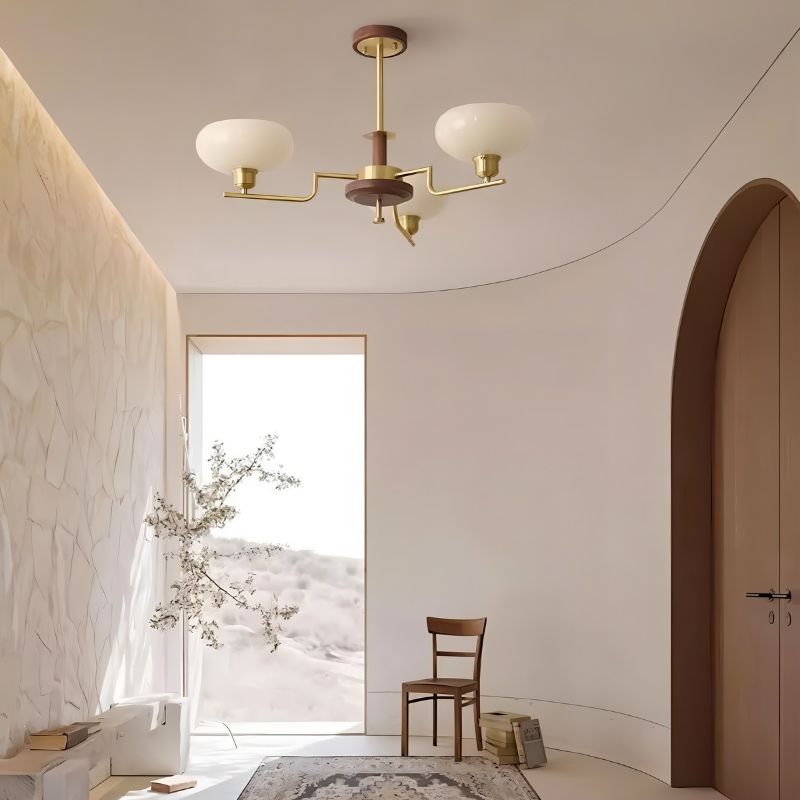 Eronix chandelier by Residence Supply featuring brass, wood, and glass elements hanging in a hallway setting.