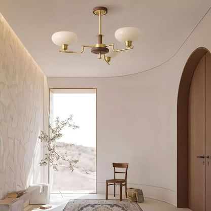 Eronix chandelier by Residence Supply featuring brass, wood, and glass elements hanging in a hallway setting.
