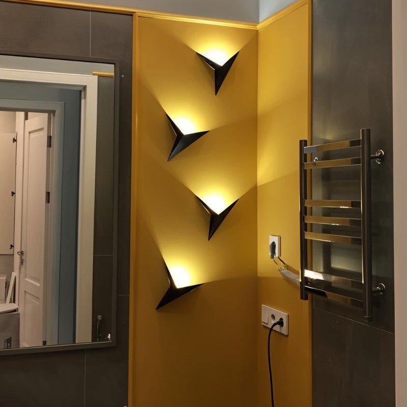 Ezio Wall Lamp by Residence Supply mounted on a wall with a modern design and metallic finish, providing stylish ambient lighting.