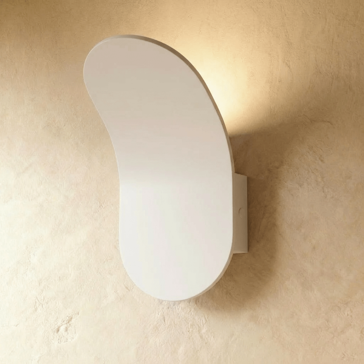 Fana Wall Lamp by Residence Supply mounted on a wall, featuring a modern design with a sleek metal finish and warm lighting.