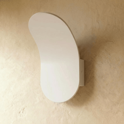 Fana Wall Lamp by Residence Supply mounted on a wall, featuring a sleek design with a white shade and metal arm for modern lighting.