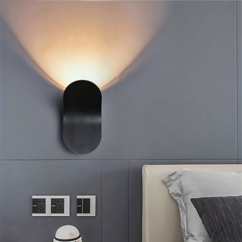 Fana Wall Lamp by Residence Supply mounted on a wall, featuring a modern design with a sleek metal finish and ambient lighting.