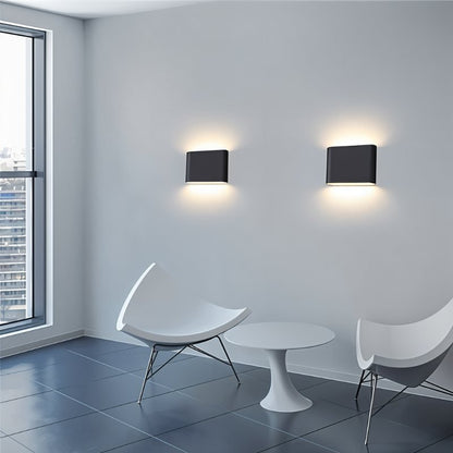 Femi Wall Lamp by Residence Supply mounted on a wall, featuring a sleek modern design with a white shade and metal arm.