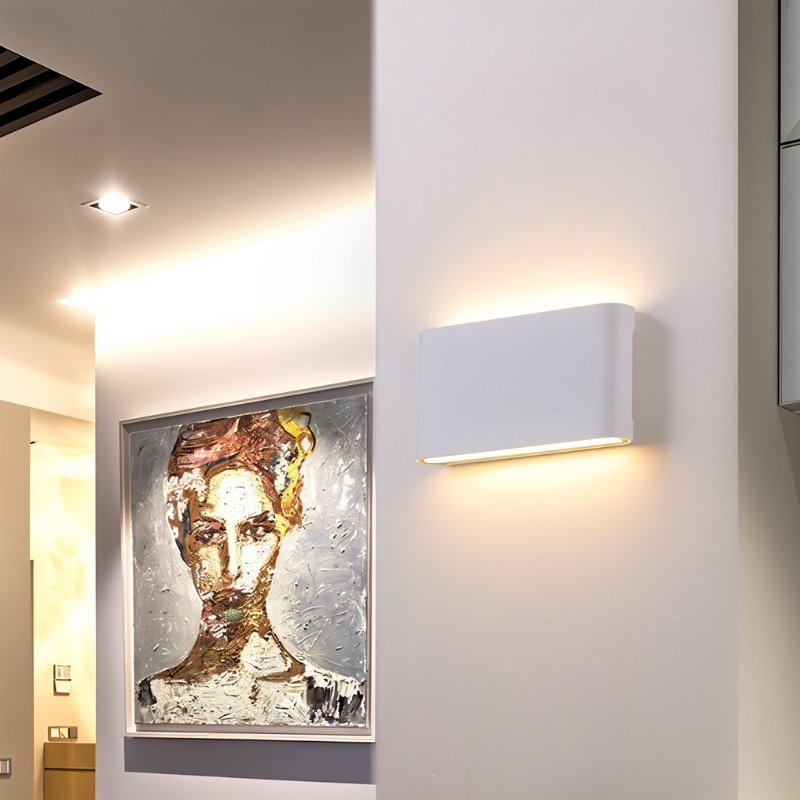Femi wall lamp by Residence Supply with a modern design and sleek metal finish mounted on a wall.