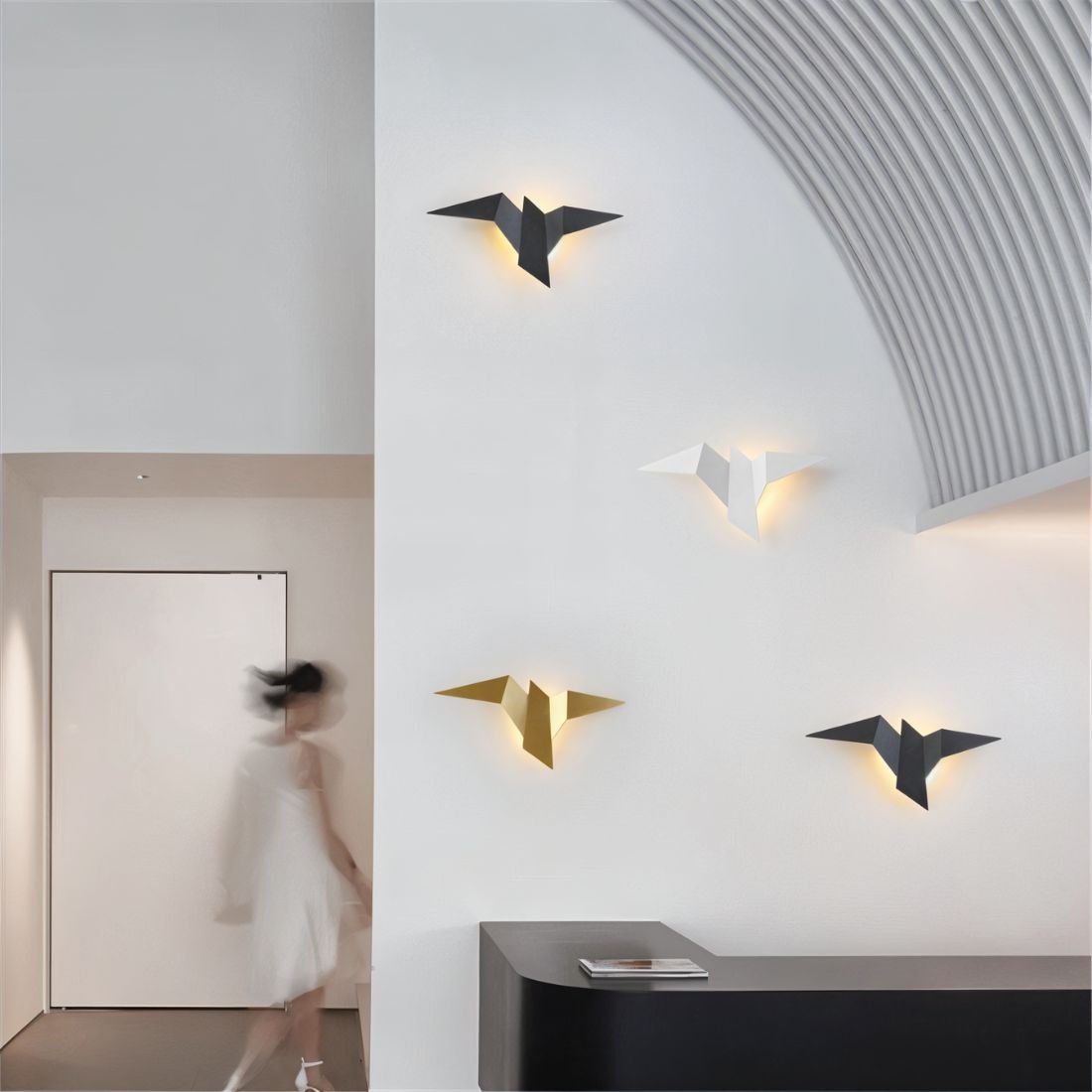 Residence Supply Finch Wall Lamp mounted on a wall with a sleek, modern design featuring a metal arm and a round shade.