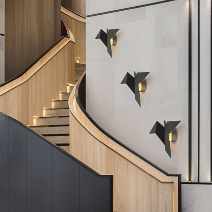 Residence Supply Finch Wall Lamp mounted on a wall, featuring a sleek, modern design with a metallic finish for stylish lighting.